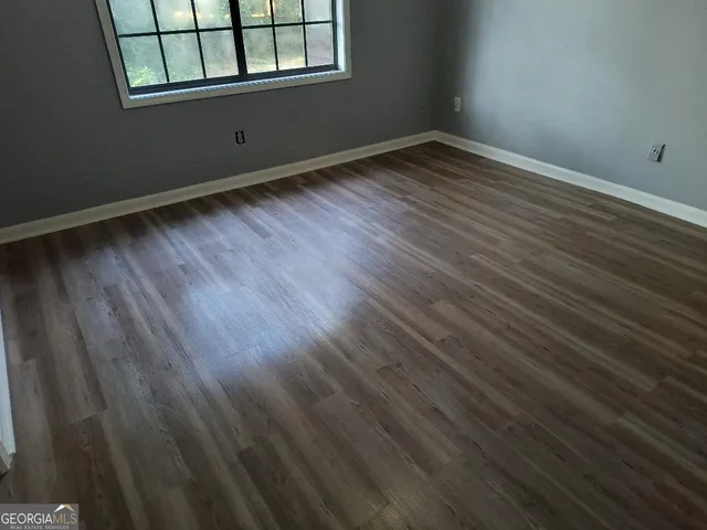 a view of a room with wooden floor and windows