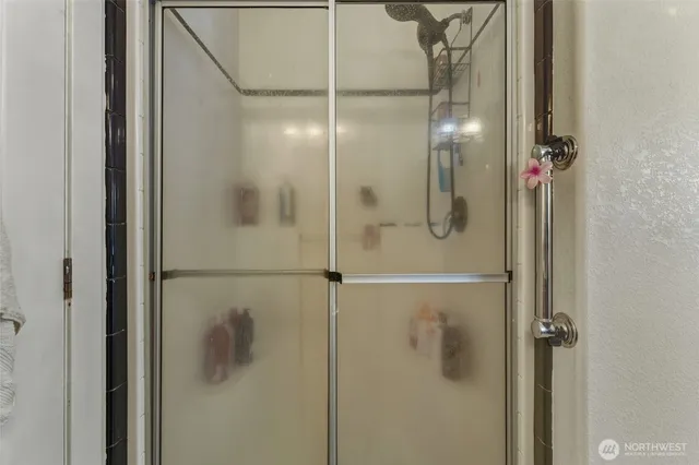 a bathroom with a glass shower door and a shower