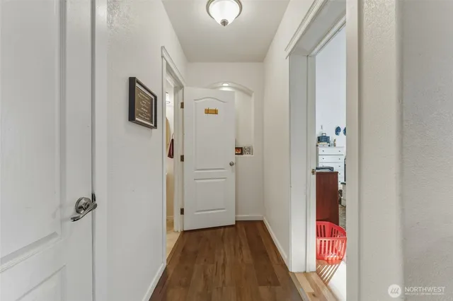 a view of a hallway with wooden floor and entryway