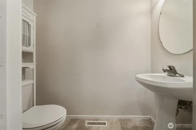 a bathroom with a sink a toilet and mirror