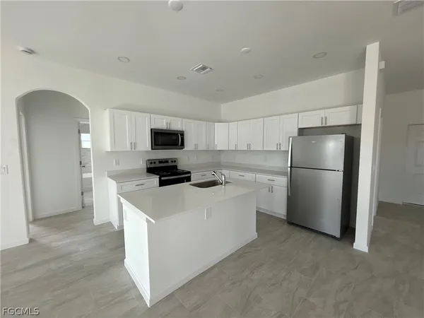 a kitchen with stainless steel appliances a refrigerator stove and microwave