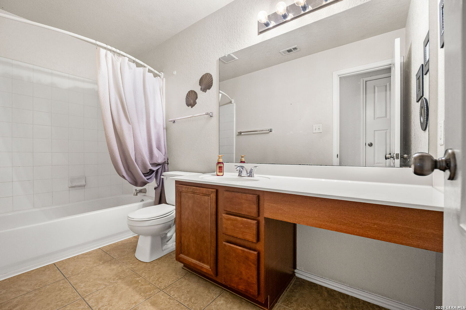 7207 Avery Road Live Oak, TX 78233 - Photo 24 of 32 a bathroom with a double vanity sink toilet mirror and bathtub