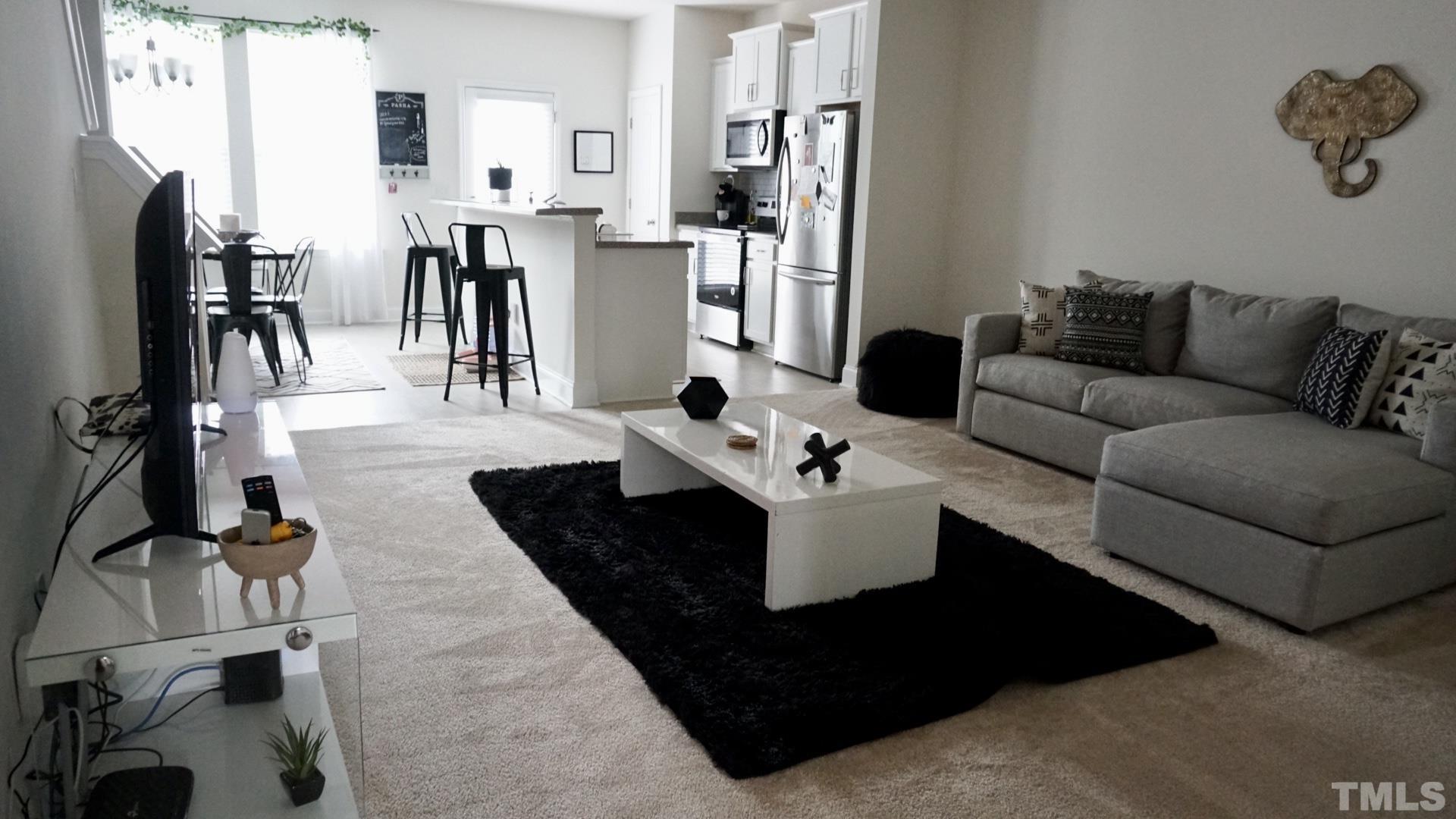 4413 Lord Joseph Court Raleigh, NC 27610 - Photo 2 of 4 a living room with stainless steel appliances furniture a rug and a kitchen view
