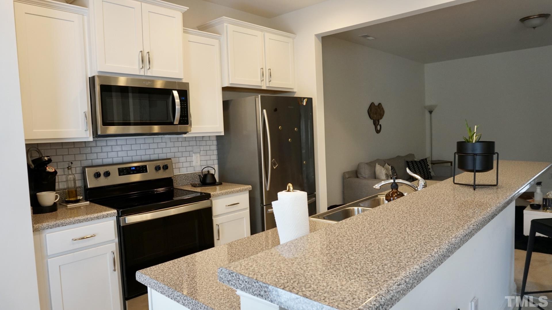 4413 Lord Joseph Court Raleigh, NC 27610 - Photo 4 of 4 a kitchen with a refrigerator sink and stove