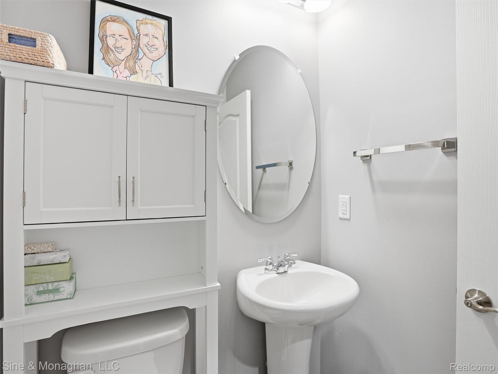 24827 Ivy Road Novi, MI 48375 - Photo 14 of 38 Pedestal sink with chrome fixtures and an oval mirror