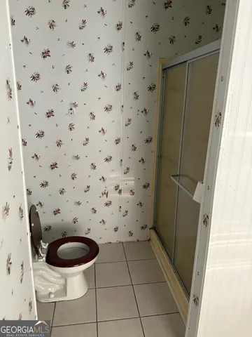 a bathroom with a toilet and a shower curtain