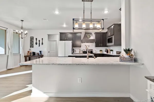 a large kitchen with kitchen island a counter space a sink stainless steel appliances and cabinets