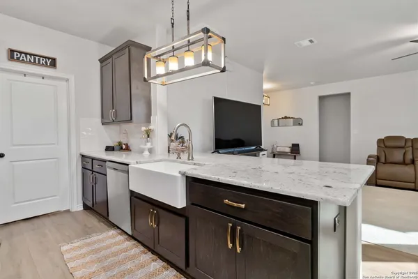 a kitchen with a sink dishwasher a stove a microwave oven with a dining table and chairs