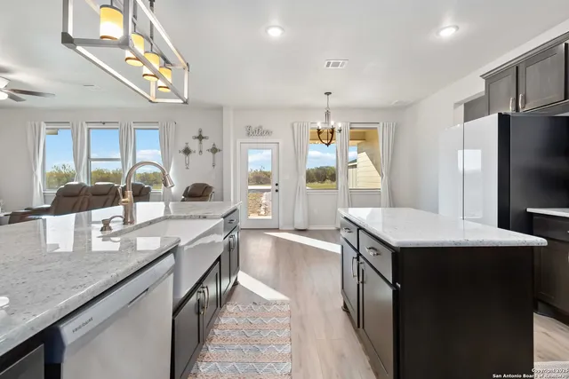 a kitchen with granite countertop stainless steel appliances a sink stove and refrigerator