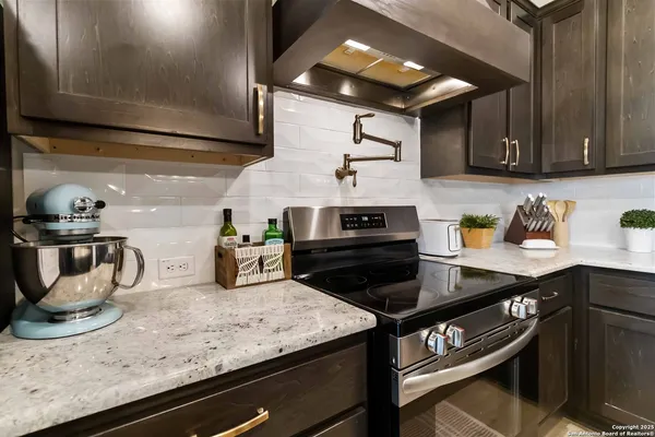 a kitchen with granite countertop stainless steel appliances and wooden cabinets