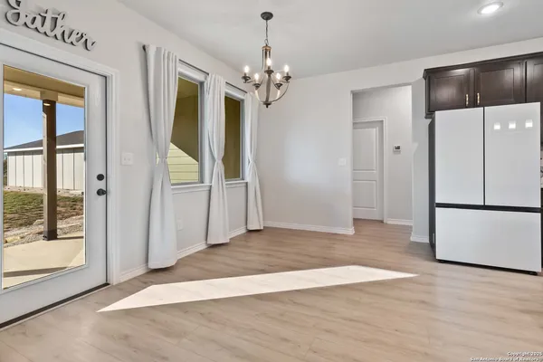 a view of a hallway with wooden floor and a chandelier