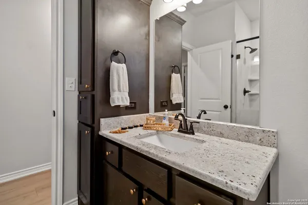 a bathroom with a granite countertop sink and a mirror