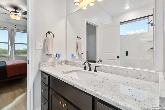 a bathroom with a granite countertop sink a mirror and a bathtub