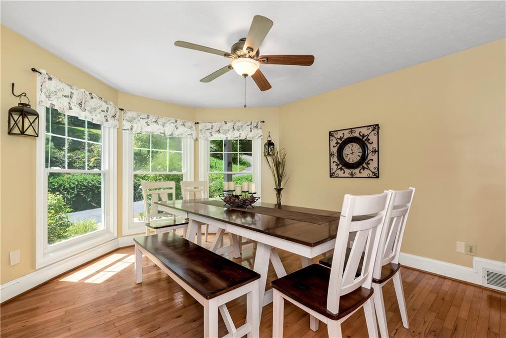 276 Zeppelin Strasse Helen, GA 30545 - Photo 17 of 60 a dining room with wooden floor a chandelier with a glass table and chairs
