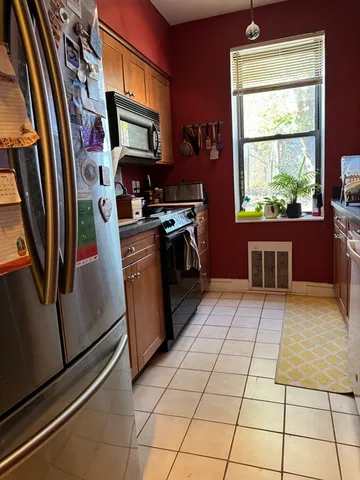 a kitchen with stainless steel appliances granite countertop a refrigerator a stove top oven and a sink