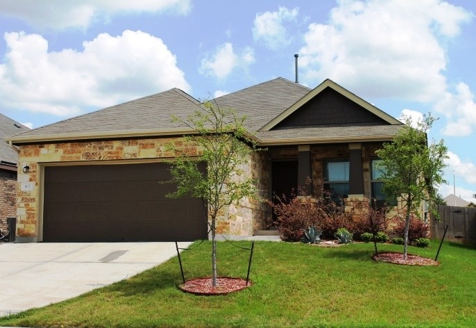 437 Travertine Trail Buda, TX 78610 - Photo 1 of 1 a front view of a house with garden