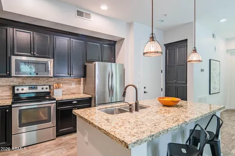 a kitchen with stainless steel appliances granite countertop a stove refrigerator sink and cabinets