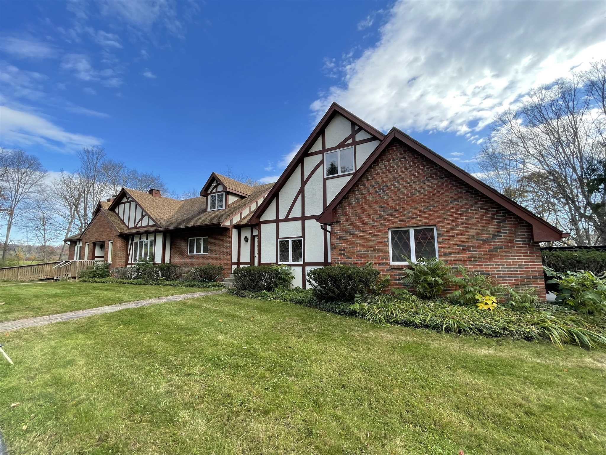 a view of a yard in front of a house with large trees