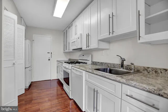 a kitchen with granite countertop a sink and cabinets