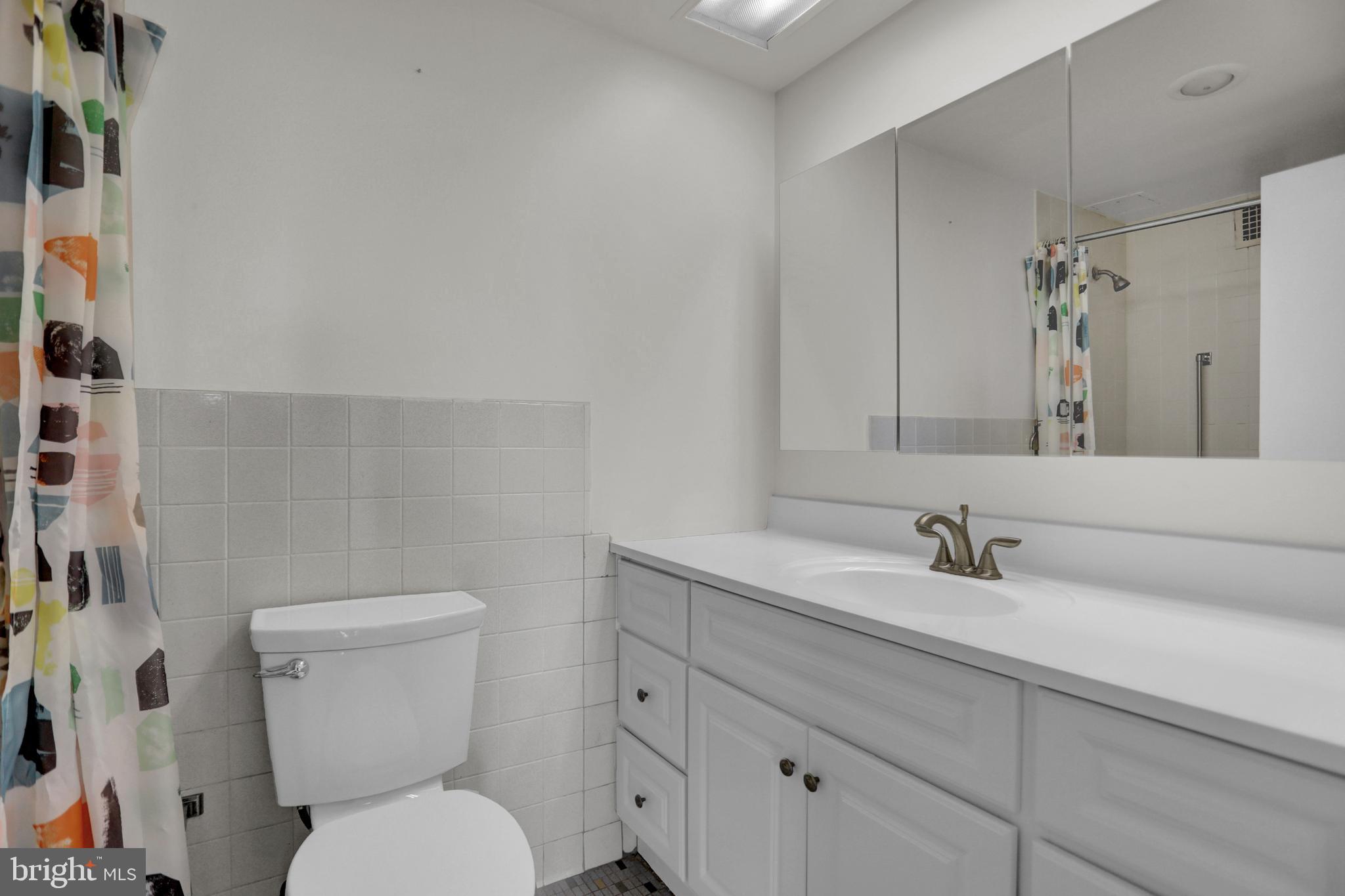 4401 Roland Avenue, Unit 304 Baltimore, MD 21210 - Photo 18 of 50 a bathroom with a toilet sink and mirror