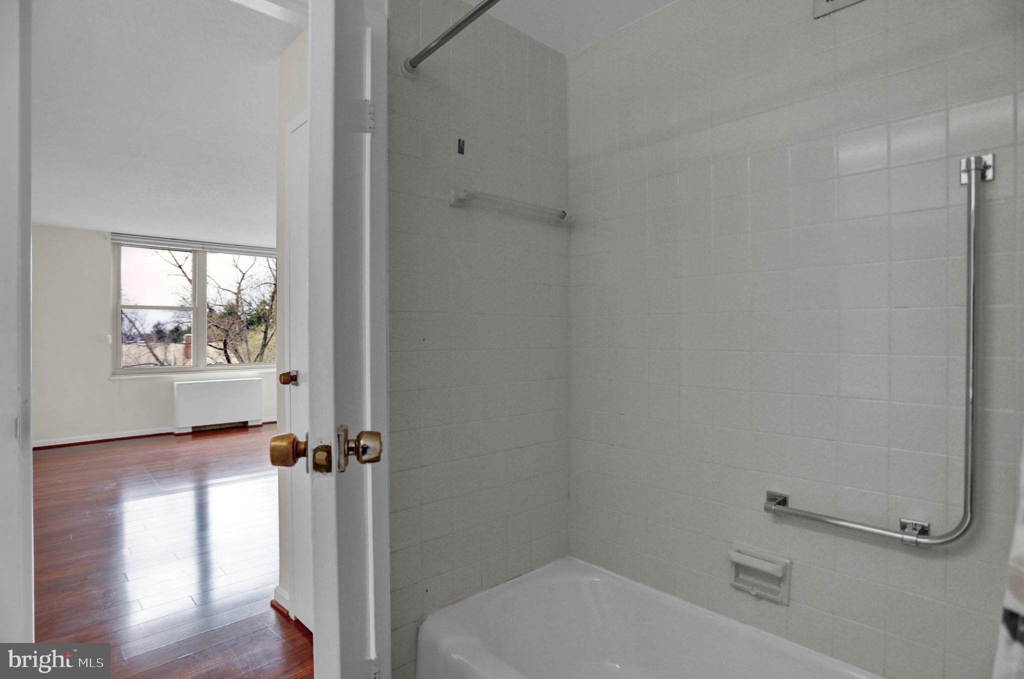 4401 Roland Avenue, Unit 304 Baltimore, MD 21210 - Photo 19 of 50 a bathroom with a bathtub and a window