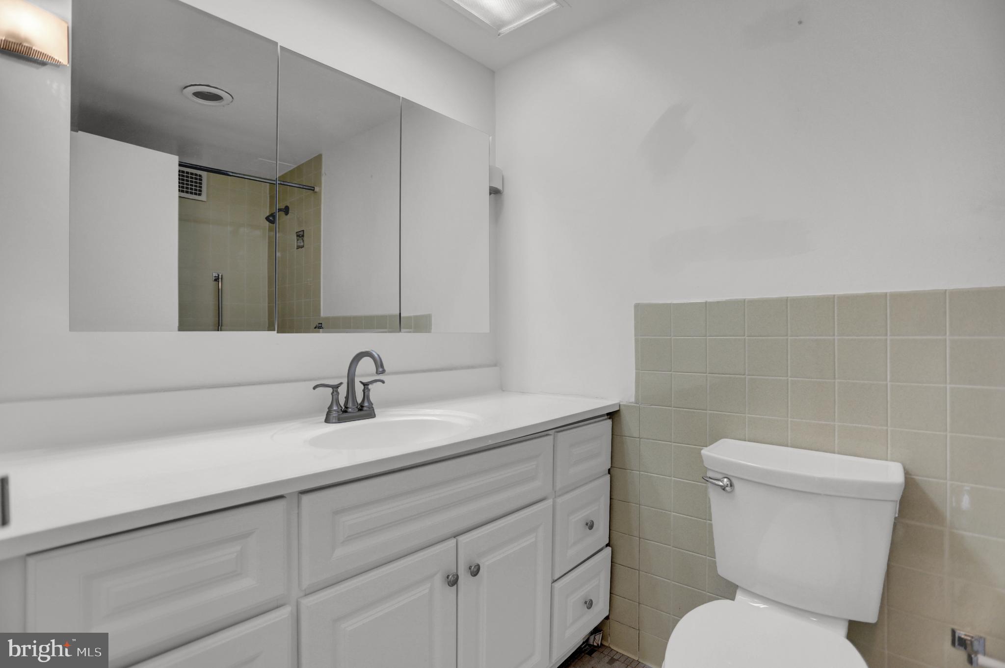 4401 Roland Avenue, Unit 304 Baltimore, MD 21210 - Photo 22 of 50 a bathroom with a toilet sink and mirror