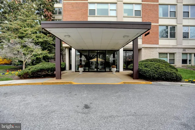 a view of pool with lawn chairs and plants