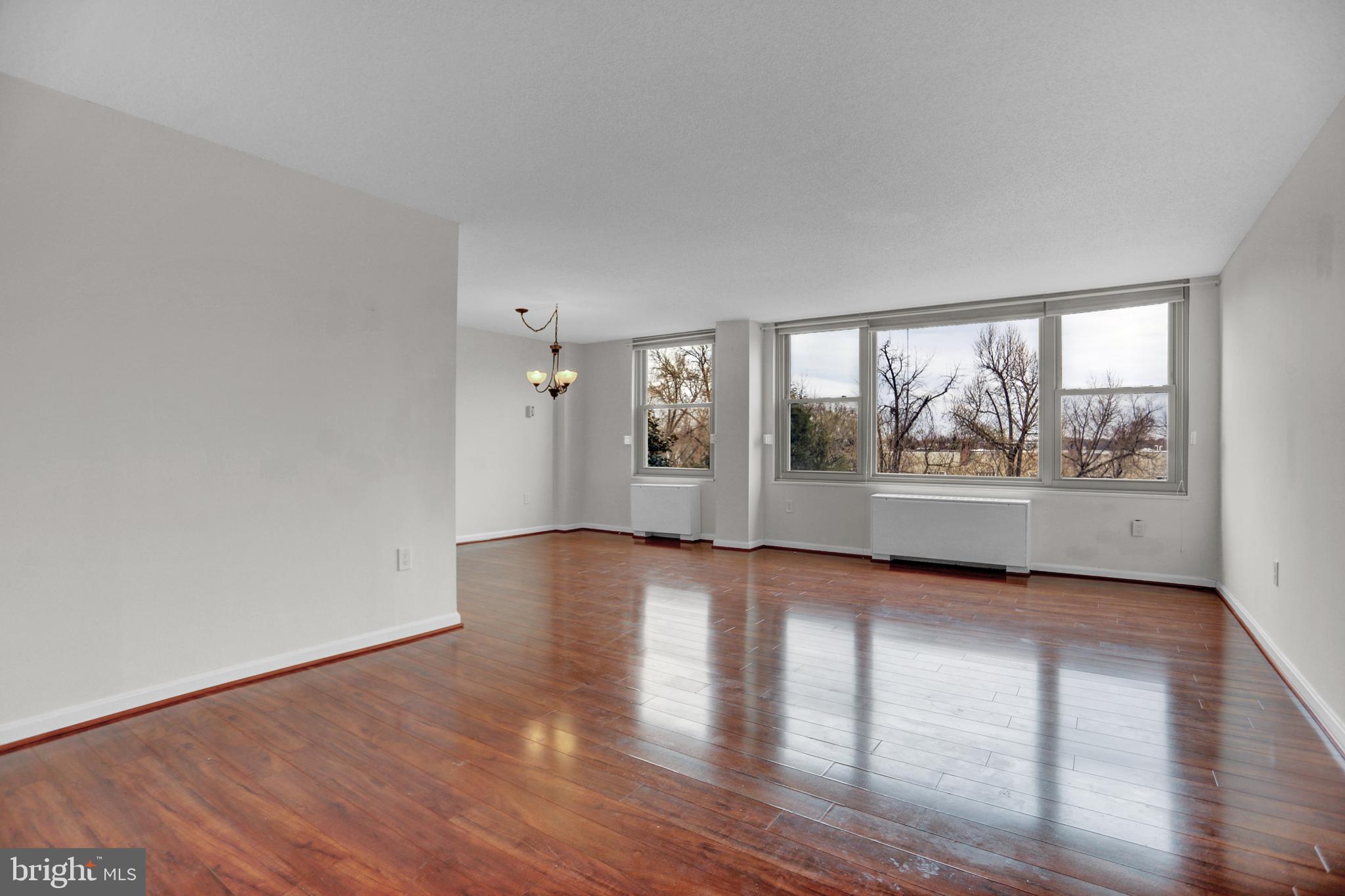 4401 Roland Avenue, Unit 304 Baltimore, MD 21210 - Photo 5 of 50 a view of an empty room with wooden floor and a window