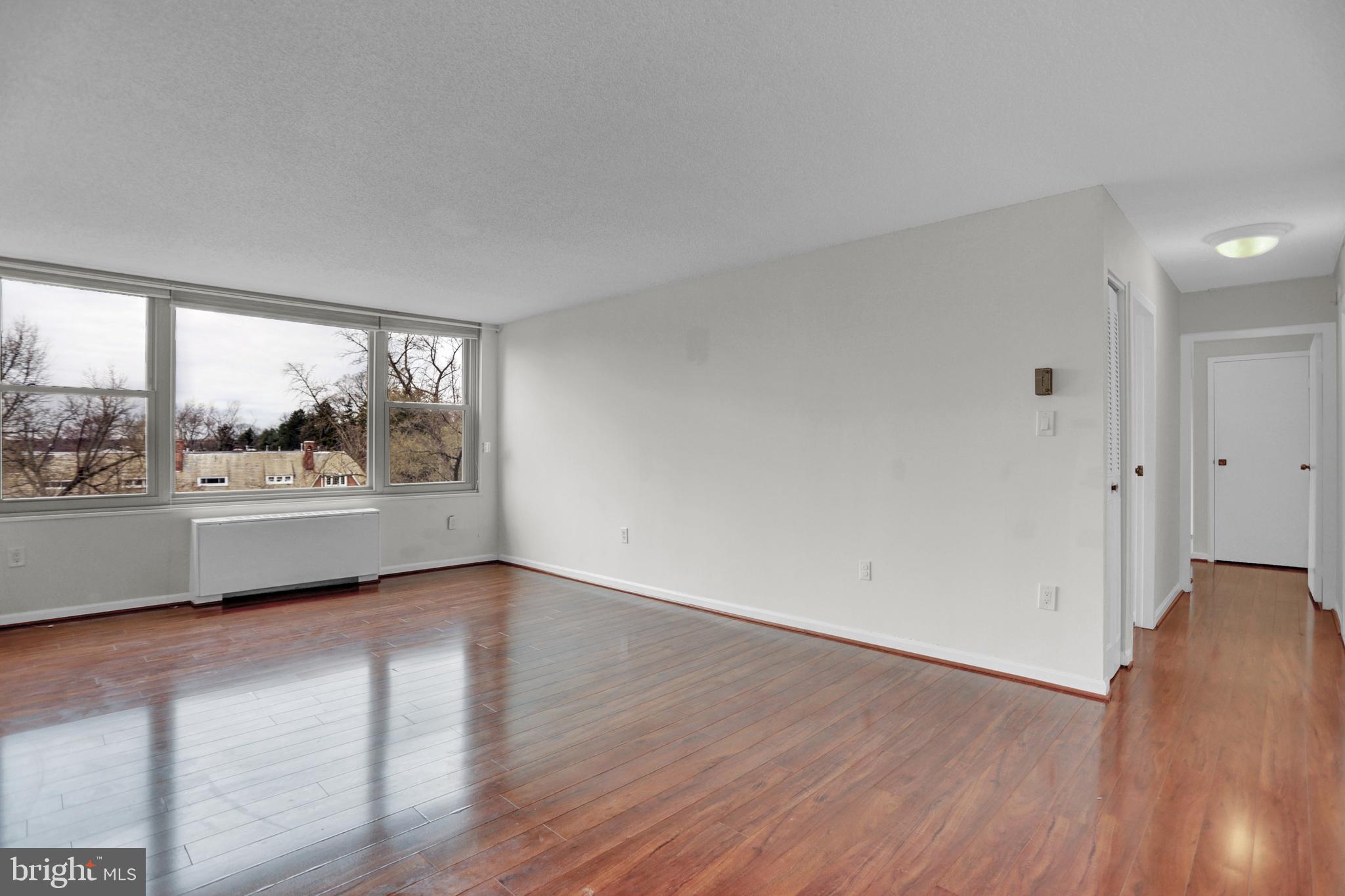 4401 Roland Avenue, Unit 304 Baltimore, MD 21210 - Photo 7 of 50 a view of an empty room with a window and wooden floor
