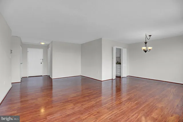 an empty room with wooden floor and window