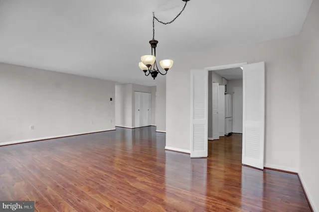 a view of a room with wooden floor and a chandelier
