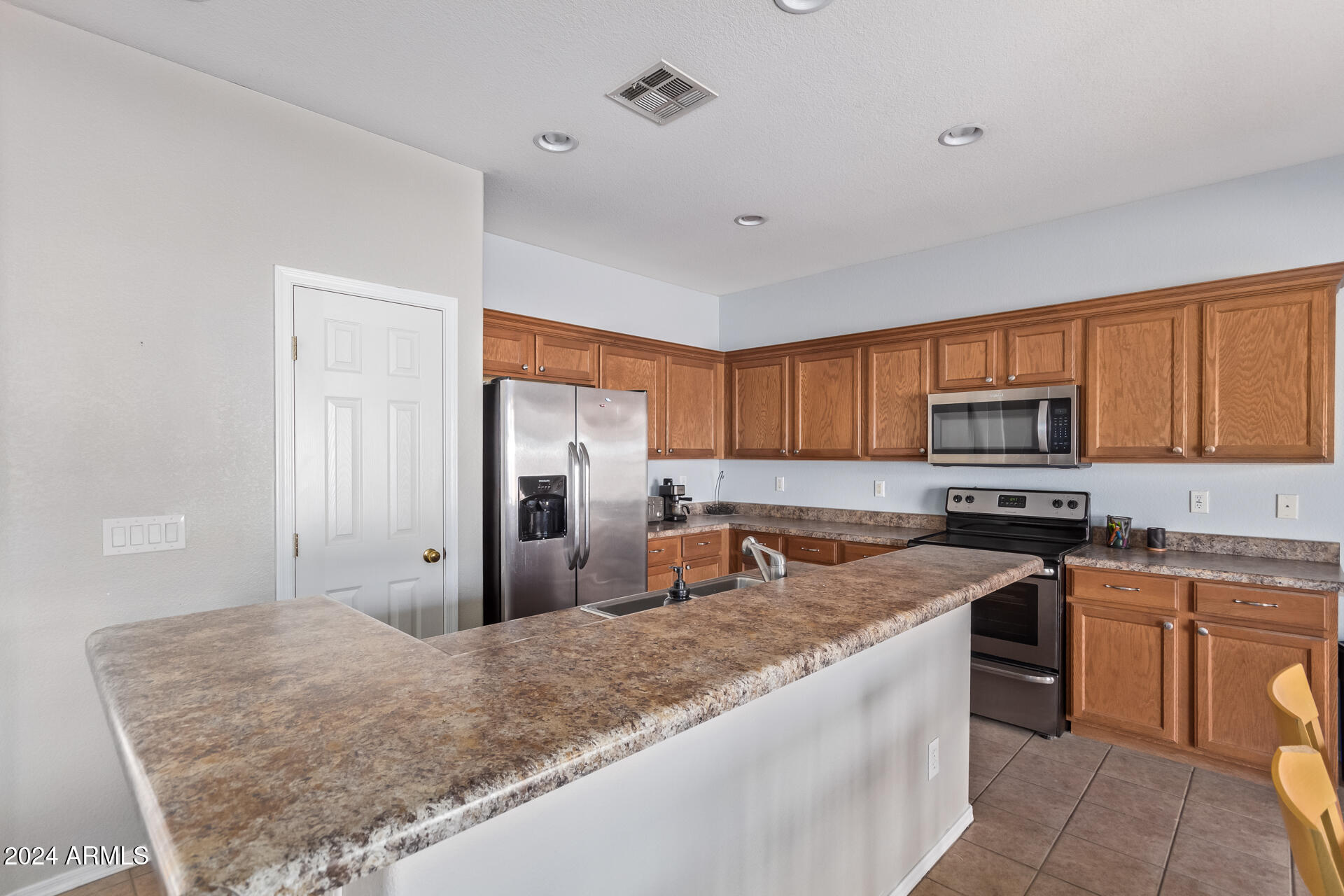 18750 East Ryan Road Queen Creek, AZ 85142 - Photo 15 of 36 a kitchen with stainless steel appliances granite countertop a stove refrigerator sink and dishwasher