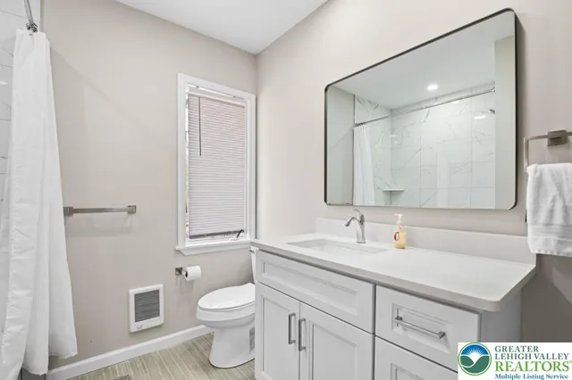 a bathroom with a toilet sink and mirror