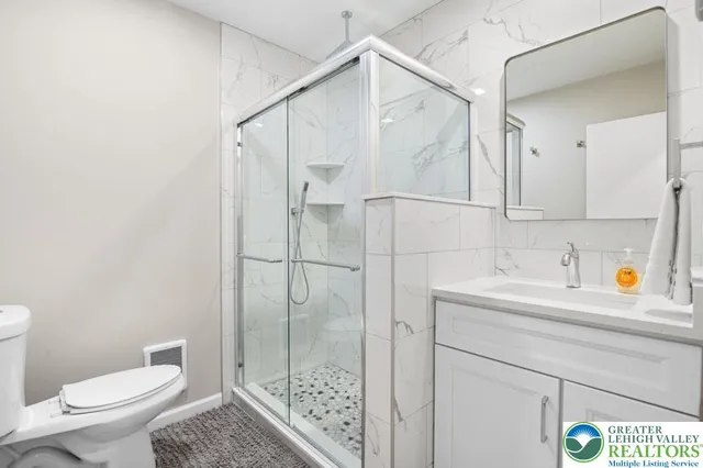 a bathroom with a sink a toilet and shower