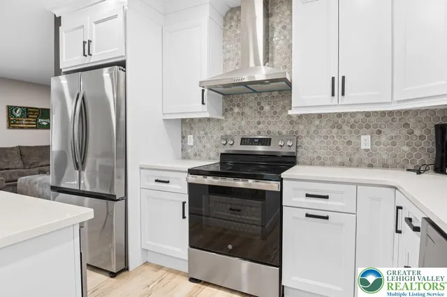 a kitchen with stainless steel appliances white cabinets and a refrigerator