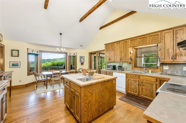 a large kitchen with kitchen island a sink a stove and wooden floor