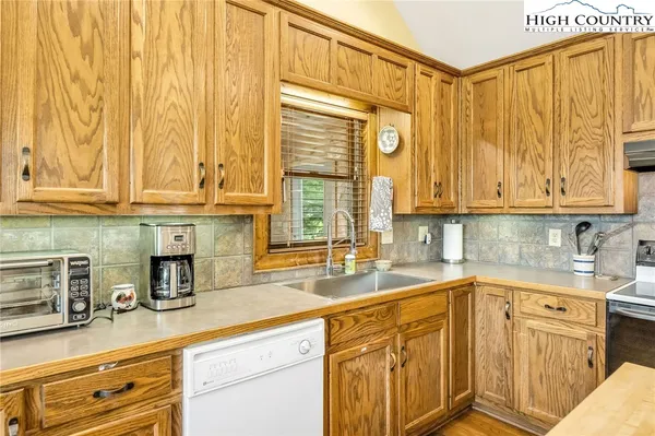 a kitchen with stainless steel appliances granite countertop white cabinets a sink and dishwasher