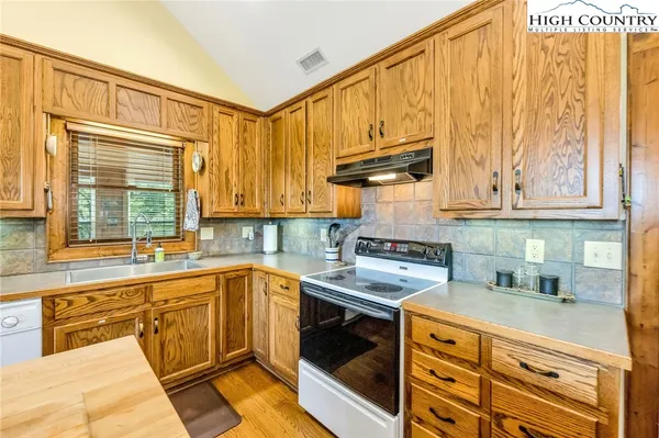 a kitchen with stainless steel appliances granite countertop a sink a stove and cabinets