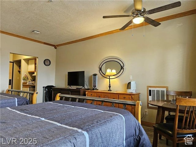 223 Hunter Ridge Drive, Unit E121 Brian Head, UT 84719 - Photo 14 of 35 Bedroom with wood finished floors, crown molding, and a textured ceiling