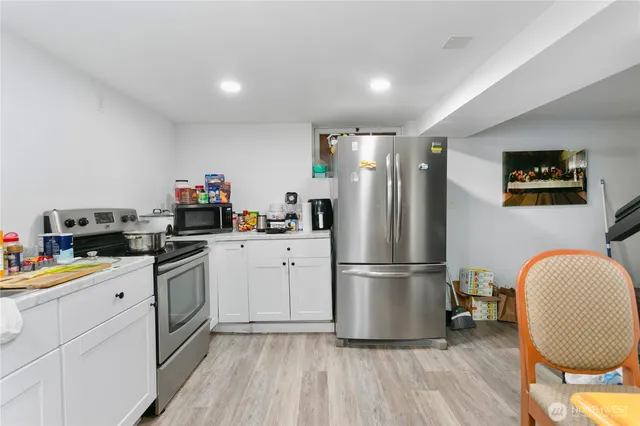 a kitchen with a refrigerator a stove and wooden floor