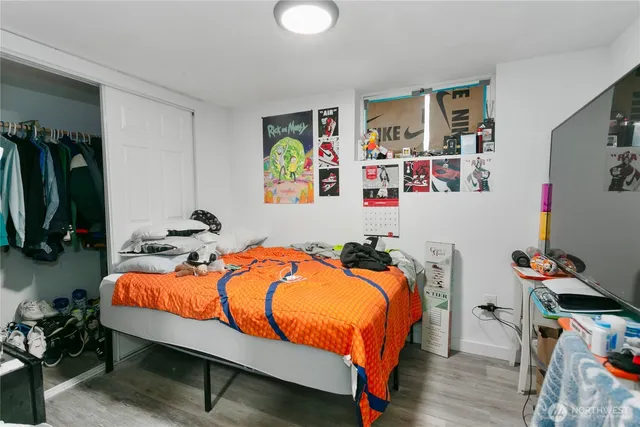a bedroom with bed and wooden floor