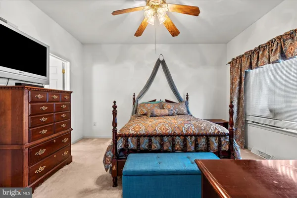 a bedroom with a bed and a flat tv screen on wall