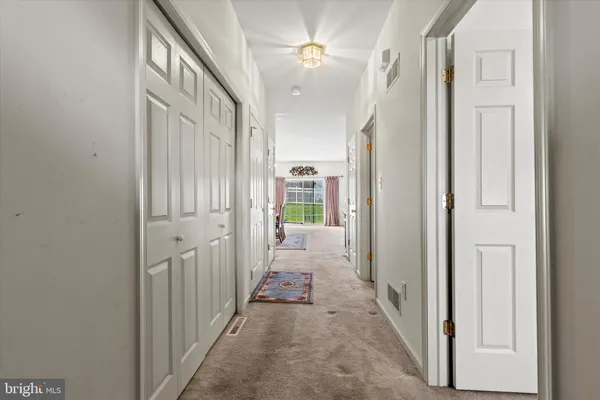 a view of a hallway with a livingroom and stairs