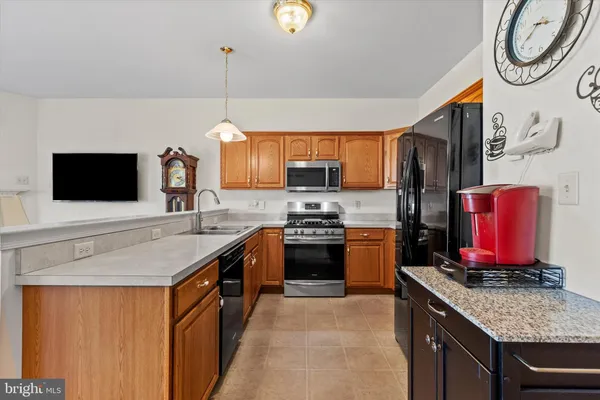 a kitchen with stainless steel appliances granite countertop a stove sink and microwave