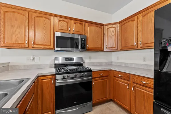 a kitchen with granite countertop cabinets stainless steel appliances and a sink