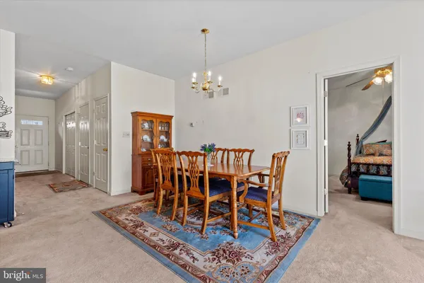 a dining room with furniture a chandelier and window