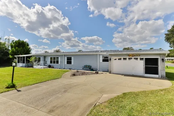 a front view of a house with a garden and trees