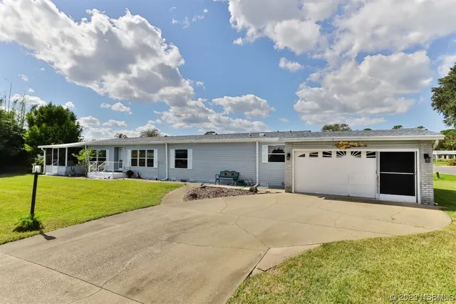 a front view of a house with a garden and trees