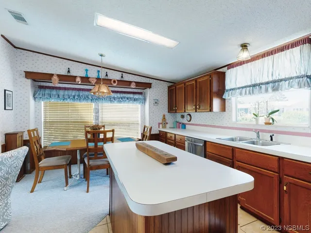 a kitchen with a sink a stove and chairs