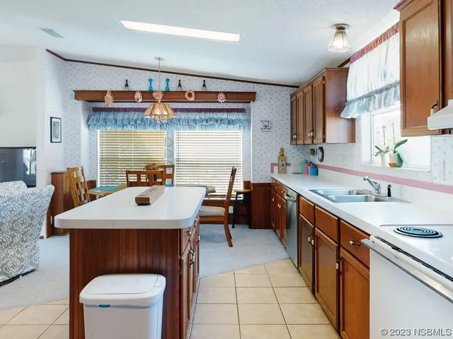 a kitchen with a sink refrigerator and cabinets